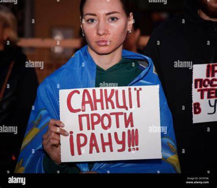 A Woman Holds A Sign Featuring Powerful Female Figers