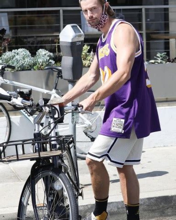 Brentwood, CA - *EXCLUSIVE* - Lakers fan Patrick Schwarzenegger enjoys his iced coffee while going for a cruise on his E-bike around Brentwood. Pictured: Patrick Schwarzenegger BACKGRID USA 15 AUGUST 2020 USA: +1 310 798 9111 / UK: +44 208 344 2007 / *UK Clients - Pictures Containing Children Please Pixelate Face Prior To Publication*