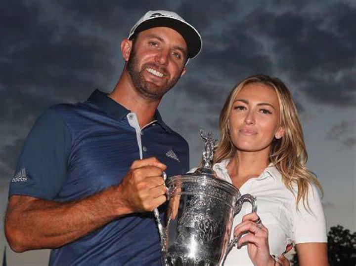 Dustin Johnson, Paulina Gretzky. United States team member Dustin Johnson and his wife Paulina Gretzky walk toward the 18th hole to watch play during the four-ball golf matches on the third day of the Presidents Cup at Liberty National Golf Club in Jersey City, N.J Presidents Cup Golf - 30 Sep 2017