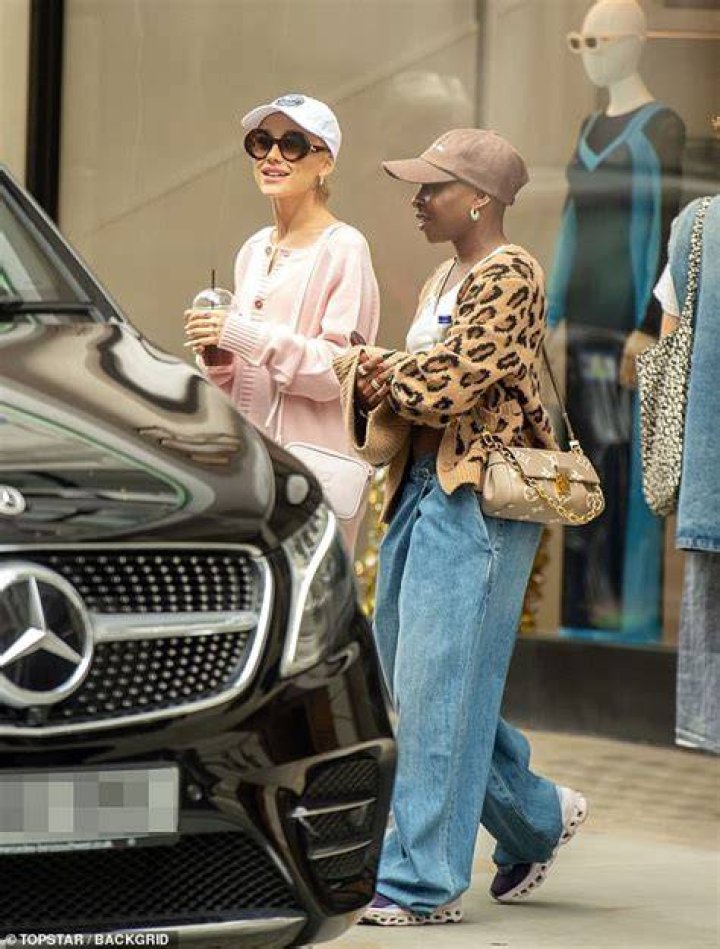 EXCLUSIVE: Ariana Grande was seen on the set of her new movie 'Wicked' for the first time in London alongside her husband Dalton Gomez. The singer, 29, cut a casual figure as she was seen departing the set and climbing into a waiting car after a day of filming the upcoming stage adaptation. Ariana is taking on the role of Glinda the Good Witch in the film adaptation of the hit Broadway musical. The hitmaker donned a pink turtle neck top for the day which she paired with a matching woolly handbag, which her new husband could be seen carrying for her. Ariana wore her locks in her trademark ponytail, also sporting a white mini skirt and was wrapped up in a brown coat. The two could also be seen wearing matching pink facemasks as they walked around the studios. Dalton, 27, cut a casual figure in a brown T-shirt and black trousers along with a matching cap. Ariana is reportedly set to rent a mammoth eight-figure mega mansion in London while she is in the UK working on Wicked. 27 Sep 2022 Pictured: Ariana Grande, Dalton Gomez. Photo credit: MEGA TheMegaAgency.com +1 888 505 6342 (Mega Agency TagID: MEGA902079_018.jpg) [Photo via Mega Agency]