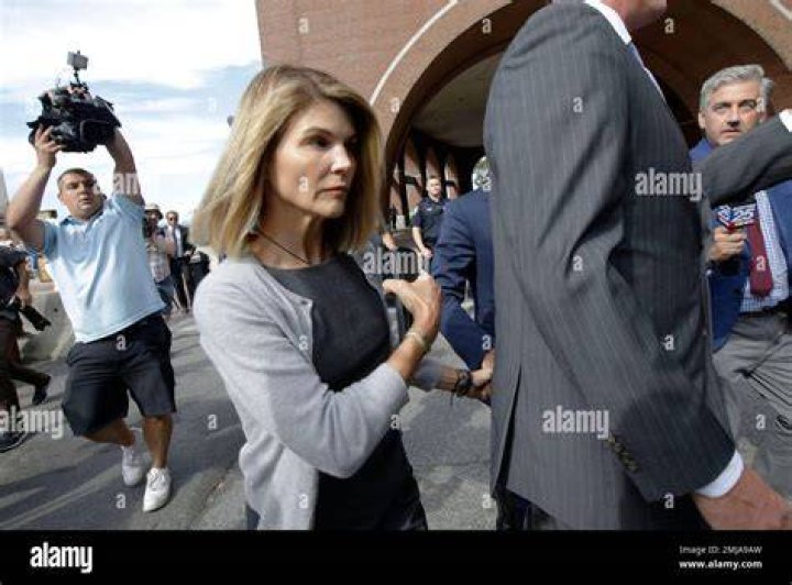 Lori Loughlin depart federal court with her husband, clothing designer Mossimo Giannulli, left, on Tuesday, Aug. 27, 2019, in Boston, after a hearing in a nationwide college admissions bribery scandal. (AP Photo/Philip Marcelo)