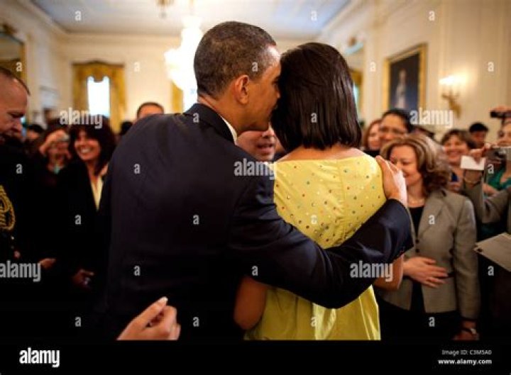 President Barack Obama kisses first lady Michelle Obama as they await for the arrival of President-elect Donald Trump and his wife Melania, Friday, Jan. 20, 2017, at the White House in Washington. (AP Photo/Evan Vucci)