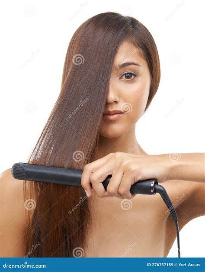 Woman straightening her hair